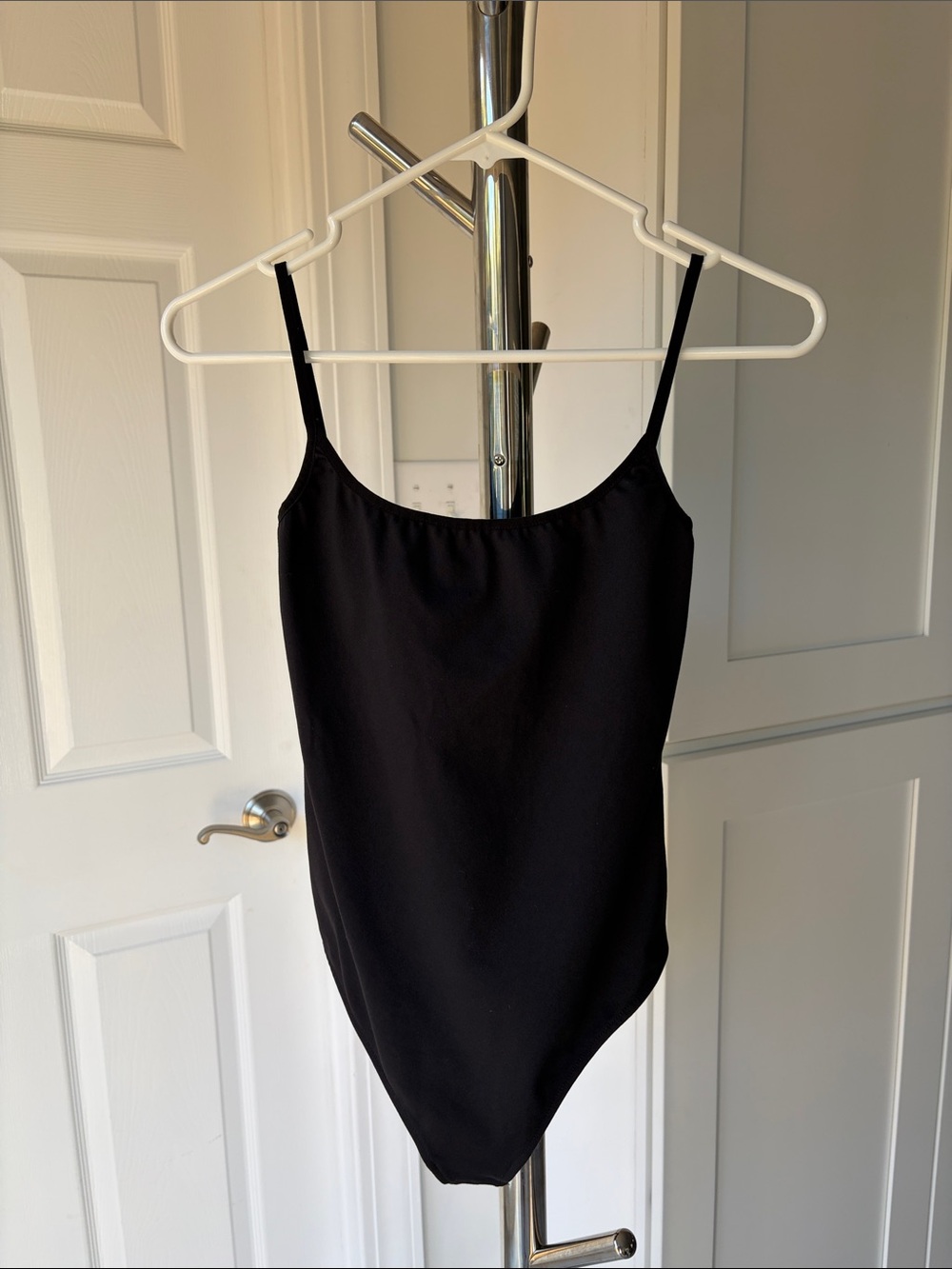 Sleek Black Women's Bodysuit with Slim Straps, Size XS.